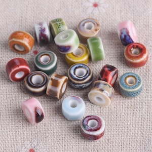 May include: Assortment of colourful ceramic beads with various patterns and designs. The beads are round and have a hole in the centre for stringing.