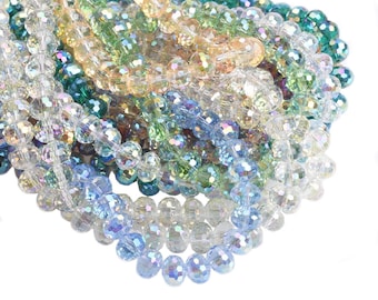 May include: A multi-strand necklace of iridescent glass beads in shades of blue, green, and beige. The beads are faceted and have a shimmering effect.
