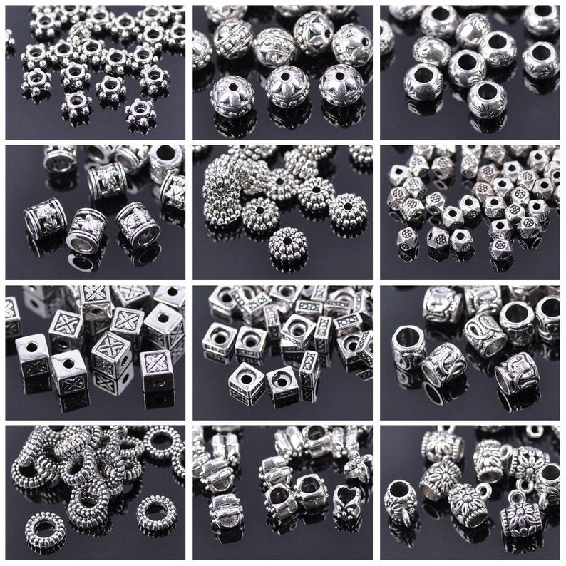 May include: Assortment of silver metal beads in various shapes and sizes, including round, square, and heart-shaped beads. The beads have intricate designs and are perfect for jewellery making.