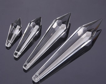 May include: Four clear crystal teardrop-shaped pendants of varying sizes. The pendants are faceted and have a pointed tip.