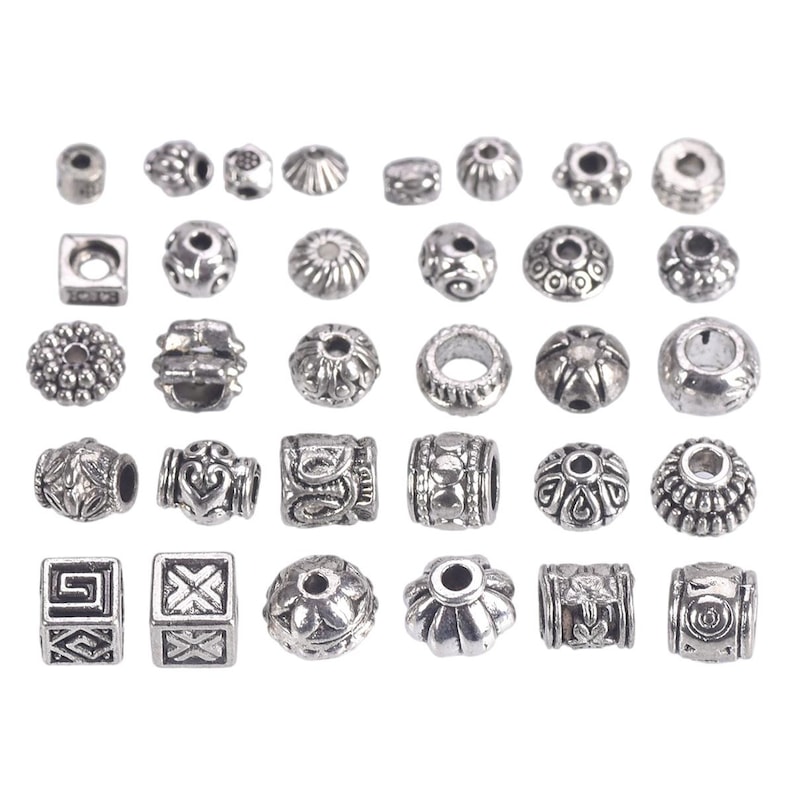 May include: A collection of silver-toned metal beads with various designs, including geometric, floral, and abstract patterns. The beads are ideal for jewellery making, crafting, and DIY projects.