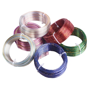 Peut inclure: Assortiment de bobines de fil métallique de différentes couleurs. Les bobines sont en fil argenté, doré, rouge, bleu et vert. Le fil est fin et a une finition brillante.