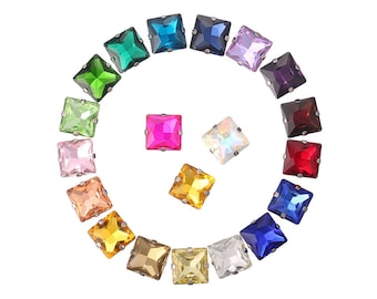 May include: Assortment of colourful square-shaped rhinestones with silver settings. The rhinestones are arranged in a circle with a gap in the middle.