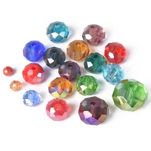 May include: Assortment of faceted glass beads in various colors, including red, green, blue, and purple. The beads are round and have a hole in the center for stringing.