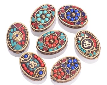 Könnte beinhalten: Acht ovale Perlen mit komplizierten Designs. Jede Perle ist aus Messing gefertigt und weist ein anderes Muster aus türkisfarbenen, roten und blauen Steinen auf. Die Perlen sind perfekt für die Schmuckherstellung oder andere Bastelprojekte.