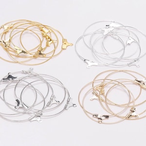 May include: A set of four earring hoops, two gold and two silver. Each set contains five hoops of varying sizes.