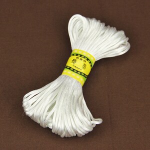 May include: A spool of white waxed cord with a yellow label that reads "精緻  精緻  精緻".