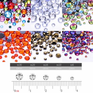 May include: Assortment of clear, red, gold, and iridescent rhinestones in various sizes. The sizes are labelled ss30, ss20, ss16, ss10, and ss6 with corresponding measurements in millimetres. A ruler is included for size reference.