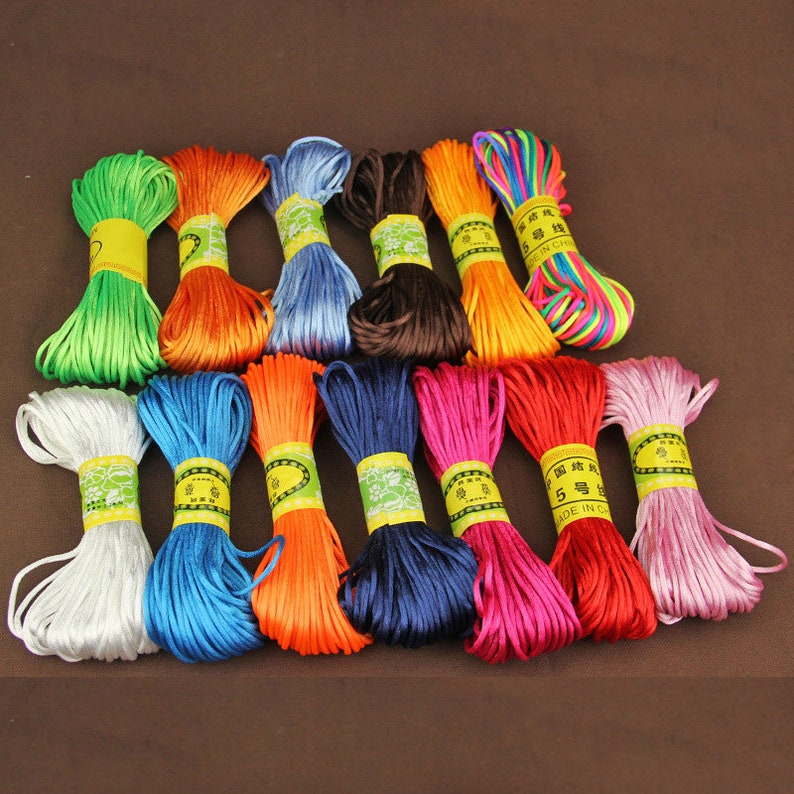 May include: Assortment of 15 spools of colorful waxed cotton cord. The cords are arranged in rows and are all the same size. The cords are in various colors, including green, orange, blue, brown, yellow, red, pink, and white.