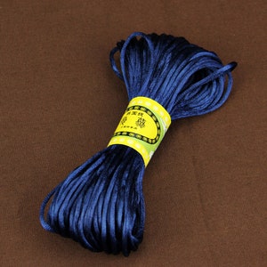 May include: A spool of dark blue waxed cord with a yellow label that says "精選絲線" in Chinese characters.