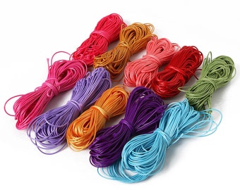 May include: Assortment of 10 spools of colorful waxed cotton cord. The cords are arranged in a rainbow pattern, with each spool featuring a different color: pink, purple, orange, dark purple, light blue, red, light pink, gold, green, and light blue.