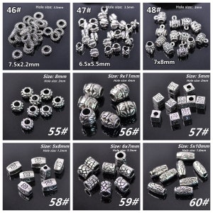 May include: Assortment of silver-toned metal beads and charms for jewellery making. The beads are various shapes and sizes, including round, oval, square, and rectangular. Some beads have decorative designs, while others are plain. The beads are arranged in rows on a black background. The image includes the text "46#", "47#", "48#", "55#", "56#", "57#", "58#", "59#", "60#", and the size and hole size of each bead.