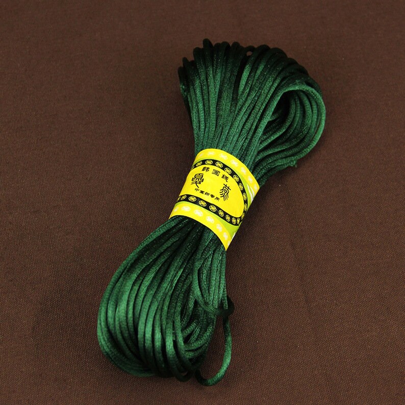 May include: A spool of dark green waxed cord with a yellow label that reads "愛  情  緣  " in Chinese characters.