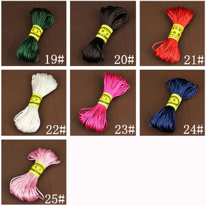 May include: Assortment of 10 colors of waxed cotton cord, each color is wound into a coil. The colors are green, black, red, white, pink, blue, light pink, dark green, dark blue, and light blue. Each coil has a yellow label with Chinese characters.