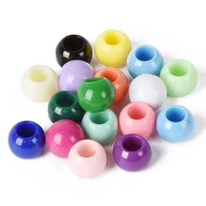 May include: Assortment of colorful plastic beads with a hole in the center. The beads are various shades of blue, green, pink, purple, yellow, white, and black.