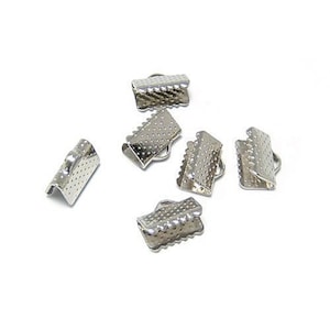 May include: Silver metal clasps for jewelry making. The clasps are small and have a textured surface.