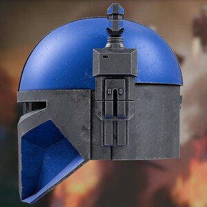 Op de afbeelding: Zijaanzicht van een helm met een felblauwe koepel en een donkergrijs metalen onderste gedeelte. Een verticale afstandsmeter is aan de rechterkant bevestigd en steekt omhoog uit een rechthoekige behuizing met geometrische details.