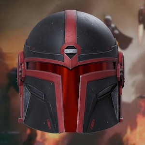 May include: A matte black and red helmet featuring a T-shaped visor, a central vertical red stripe, and angular geometric paneling. The design includes a metallic silver accent above the visor and recessed side vents on the lower faceplate.