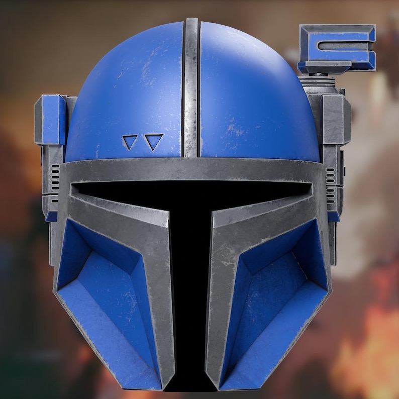 Op de afbeelding: Een blauwe helm met een donkergrijs T-vormig vizier en metalen randen. De helm heeft een verweerde afwerking, een verticale richel in het midden, twee kleine driehoekige uitsparingen op het voorhoofd en een rechthoekig opzetstuk aan de rechterkant.