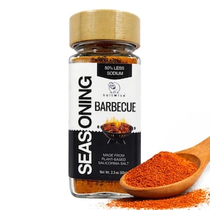 May include: A glass jar of SaltWise Barbecue seasoning with a wooden lid. The label reads "50% Less Sodium" and "Made from Plant-Based Salicornia Salt." A wooden spoon holds a pile of red seasoning, and the net weight is 2.3 oz (65g).