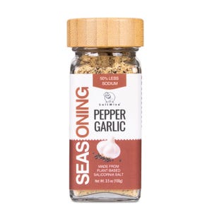 May include: A clear glass jar of SaltWise Pepper Garlic seasoning with a light brown bamboo lid. The white label features the text 50% LESS SODIUM, SEASONING, PEPPER GARLIC, and MADE FROM PLANT-BASED SALICORNIA SALT with a Net Wt. 3.5 oz (100g).