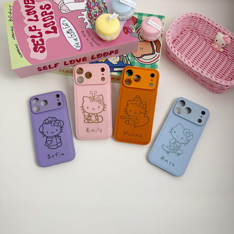 Pu&ograve; includere: Quattro custodie per telefono colorate con disegni di Hello Kitty. Le custodie sono viola, rosa, arancione e blu. Ogni custodia ha una grafica diversa di Hello Kitty e un nome: Sofia, Emily, Hanna e Anya. Un cestino rosa intrecciato e una scatola di cereali "Self Love Loops" sono anche nell'immagine.