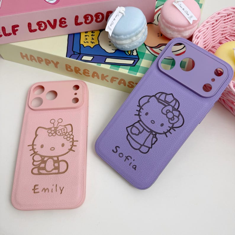 Pu&ograve; includere: Due custodie per telefono, una rosa e una viola, con un design di Hello Kitty. La custodia rosa ha il nome "Emily" e la custodia viola ha il nome "Sofia". Entrambe le custodie hanno un proteggi obiettivo.