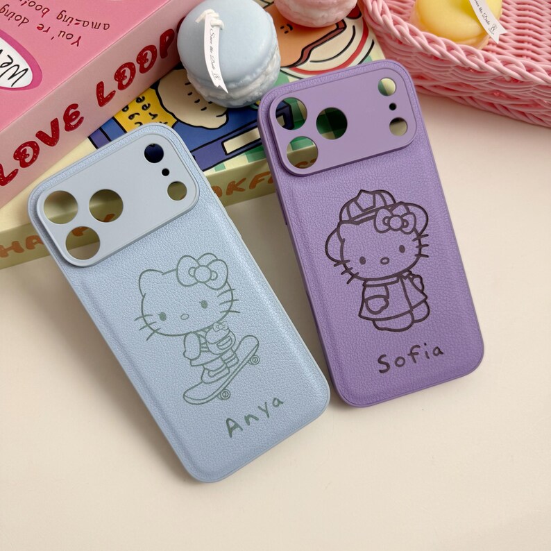 Pu&ograve; includere: Due custodie per telefono, una azzurra e una viola, con un design di Hello Kitty. La custodia azzurra ha il nome "Anya" e un Hello Kitty su uno skateboard. La custodia viola ha il nome "Sofia".