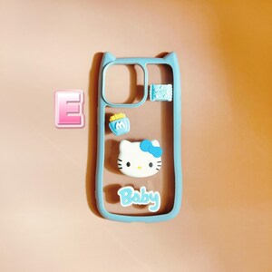 Op de afbeelding: Een lichtblauwe telefoonhoes met een transparante achterkant. De hoes heeft een Hello Kitty-personage, een klein blauw tasje met frietjes en het woord "Baby" op de achterkant.