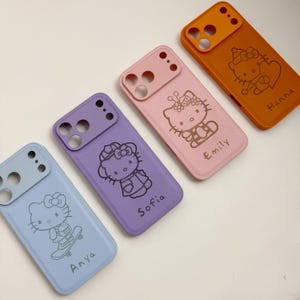 Puede incluir: Cuatro fundas de tel&eacute;fono coloridas con un dise&ntilde;o de gato de dibujos animados. Las fundas son de color azul claro, morado, rosa y naranja. Cada funda tiene una ilustraci&oacute;n de gato diferente y un nombre: Anya, Sofia, Emily y Hanna. Las fundas son de material liso.