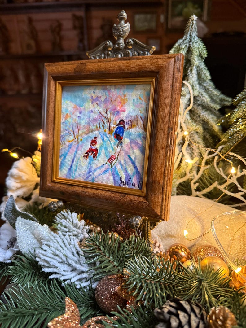 May include: A white ceramic mug with a black handle and the text "But First, Coffee" in a bold, black font. The mug is set against a blurred background, suggesting a cozy setting.