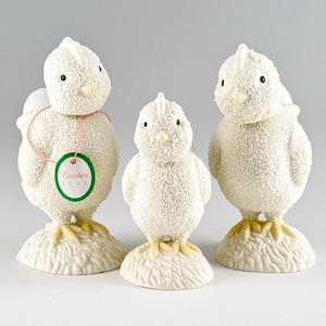 May include: Three white decorative chick figurines with textured surfaces and yellow feet. One chick has a tag that says "Easter 2002". The chicks are standing on textured bases, perfect for Easter decor.