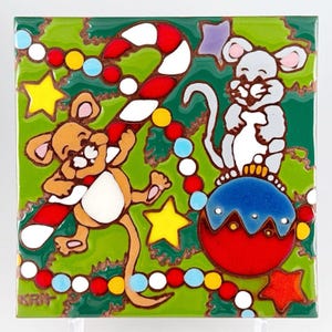 May include: A square ceramic tile with a Christmas design. Two cartoon mice are depicted, one holding a candy cane and the other perched on a red and blue bauble. The background is green with colourful star and bead decorations.