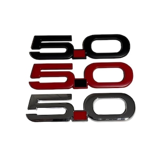 Peut inclure: Trois emblèmes 5.0 en noir, rouge et chrome. Chaque emblème a une combinaison de couleurs différente, avec les chiffres et le zéro dans une couleur contrastante. Les emblèmes sont conçus pour une utilisation automobile.