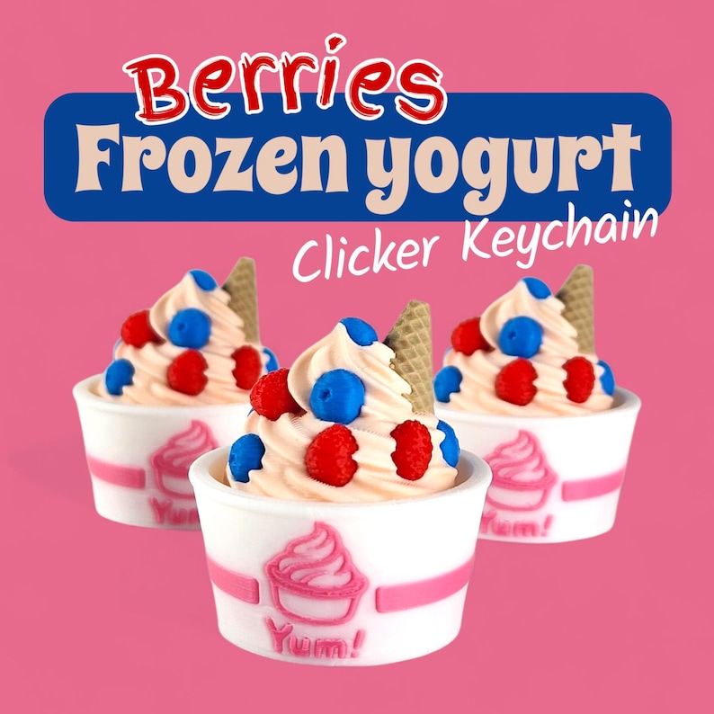 Op de afbeelding: Drie sleutelhangers met bevroren yoghurt op een roze achtergrond. Elke sleutelhanger toont een werveling van softijs, gegarneerd met rode frambozen, blauwe bosbessen en een wafel. De witte bekers hebben een roze wervelontwerp en het woord "Yum!"