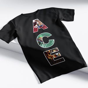 May include: Black t-shirt with the word "ACE" in white, each letter filled with a different colorful graphic. The "A" is red, the "C" is green, and the "E" is orange. The shirt is displayed on a white surface.