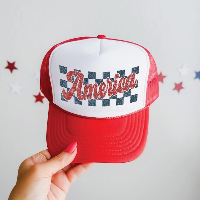 May include: Red and white trucker hat with a red brim and mesh back. The front panel is white with a checkered pattern and the word "America" in red script. A patriotic accessory.