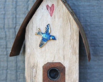 small bird house ornament made from a piece of old snow fencing - rusty metal roof