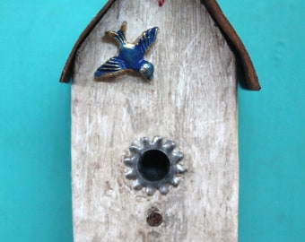 small bird house ornament made from a piece of old snow fencing - rusty metal roof