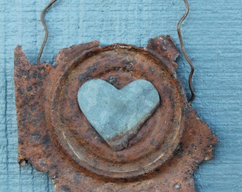 galvanized metal heart on a very distressed and rusty piece of unknown metal
