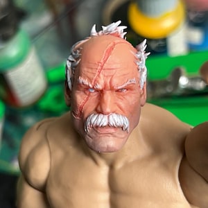 Puede incluir: Primer plano de una cabeza de figura de acción detallada pintada a mano. La figura tiene barba y bigote blancos, grises y marrones. La figura tiene una cicatriz en la frente y una cicatriz roja debajo del ojo derecho. La figura tiene una expresión seria.