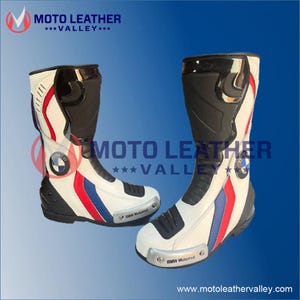 Puede incluir: Par de botas de moto blancas y negras con rayas rojas y azules. Las botas tienen el logotipo de BMW y el texto "BMW Motorrad". Las botas son de cuero y tienen un diseño protector.