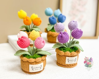 May include: Crocheted flower arrangements in pots. The flowers are made of yarn and come in a variety of colors, including pink, purple, yellow, and blue. The pots are brown and have a crocheted texture. The pots have a label that says "Handmade with love".