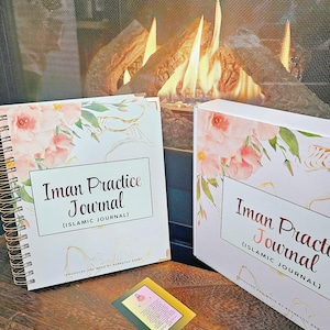 May include: Two white journals with pink floral designs and gold accents. The journals are titled "Iman Practice Journal (Islamic Journal)" and are produced and made by Barratou Barry.