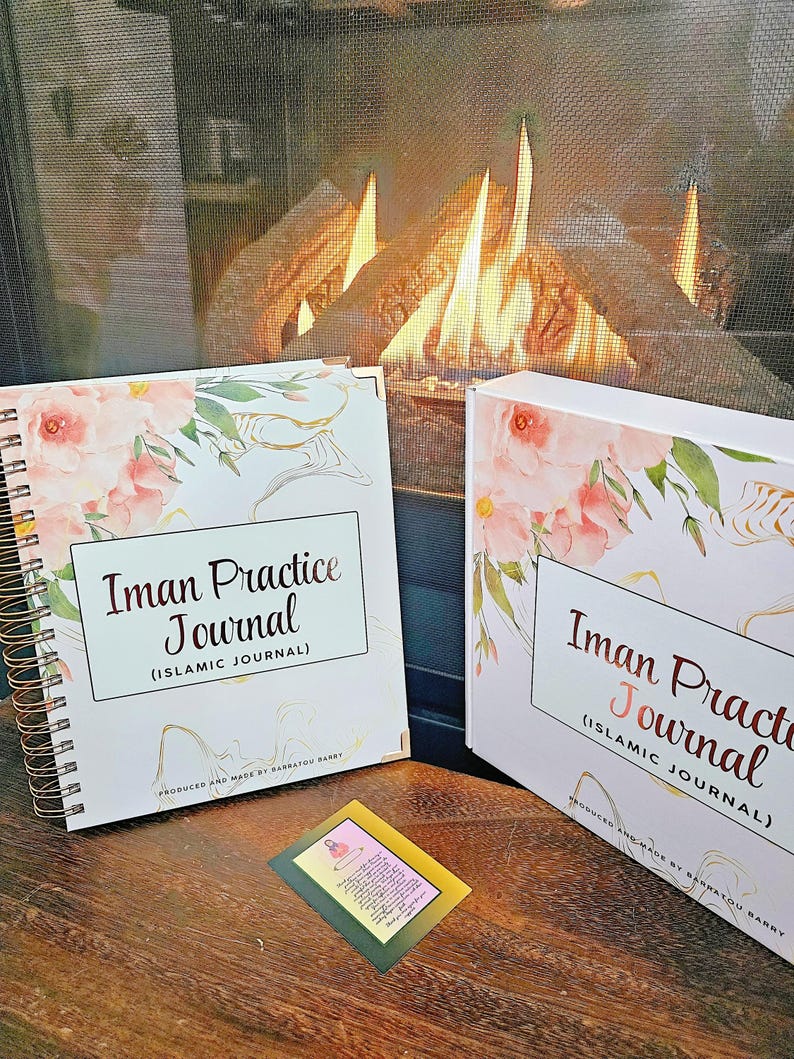 May include: Two white journals with pink floral designs and gold accents. The journals are titled "Iman Practice Journal (Islamic Journal)" and are produced and made by Barratou Barry.