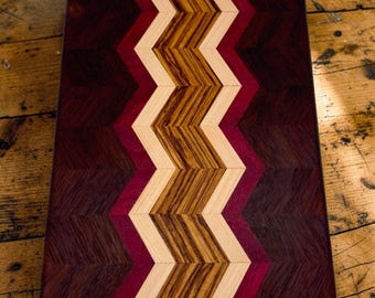 Tabla de embutidos con diseño de espiga hecha a mano, tabla de cortar y servir de madera exótica.