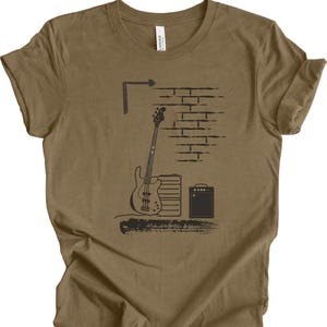 May include: A brown t-shirt with a black and white graphic of a bass guitar, an amplifier, and a brick wall.