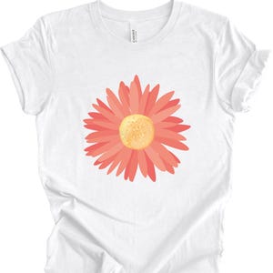 Puede incluir: Camiseta blanca con un gr&aacute;fico de margarita rosa.