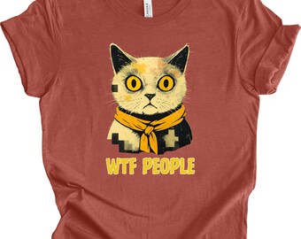 Puede incluir: Camiseta de color óxido con un gato de dibujos animados con grandes ojos amarillos y una bufanda amarilla. El gato tiene un diseño pixelado. El texto "WTF PEOPLE" está impreso en amarillo debajo del gato.