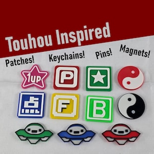 Puede incluir: Una colección de parches, llaveros, pines e imanes inspirados en Touhou. Los artículos incluyen una estrella rosa, la letra P roja y blanca, una estrella verde, un yin-yang rojo y blanco, un símbolo azul, la letra F amarilla, la letra B verde y un yin-yang blanco y negro.